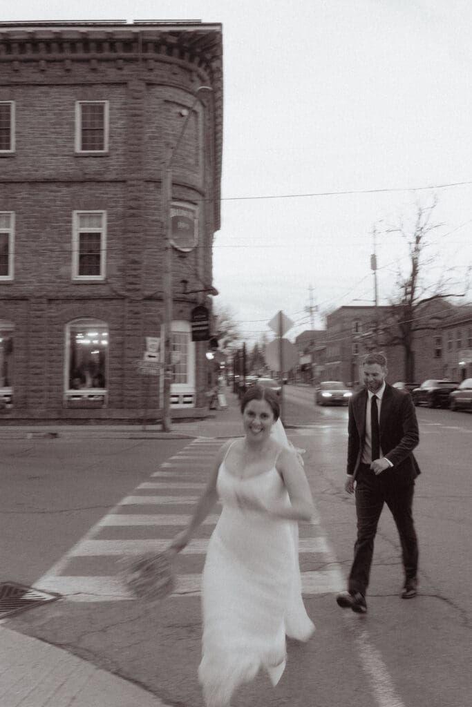 The bride and groom running through the streets of Merrickville, Ontario, and the Rideau Canal.