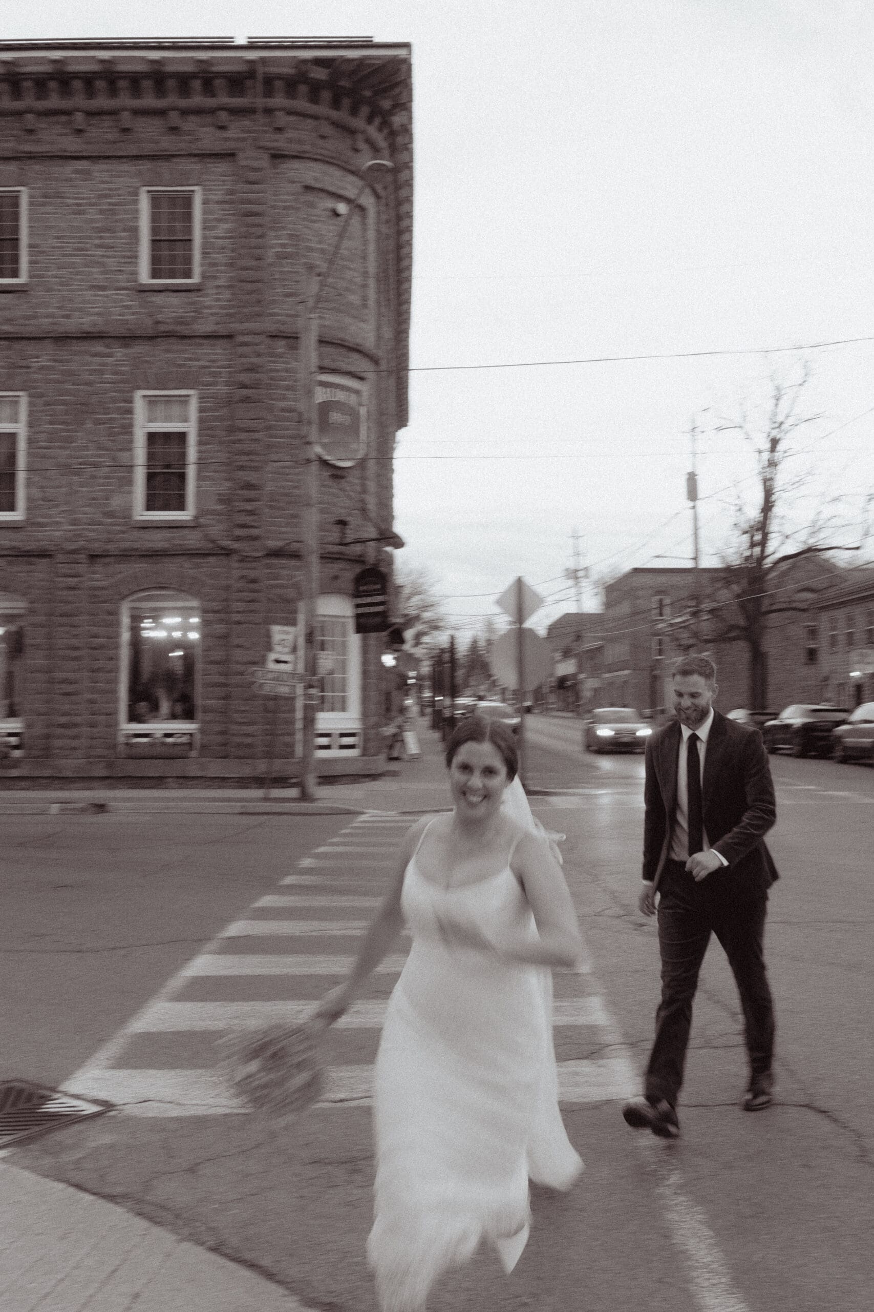 The bride and groom running through the streets of Merrickville, Ontario, and the Rideau Canal.