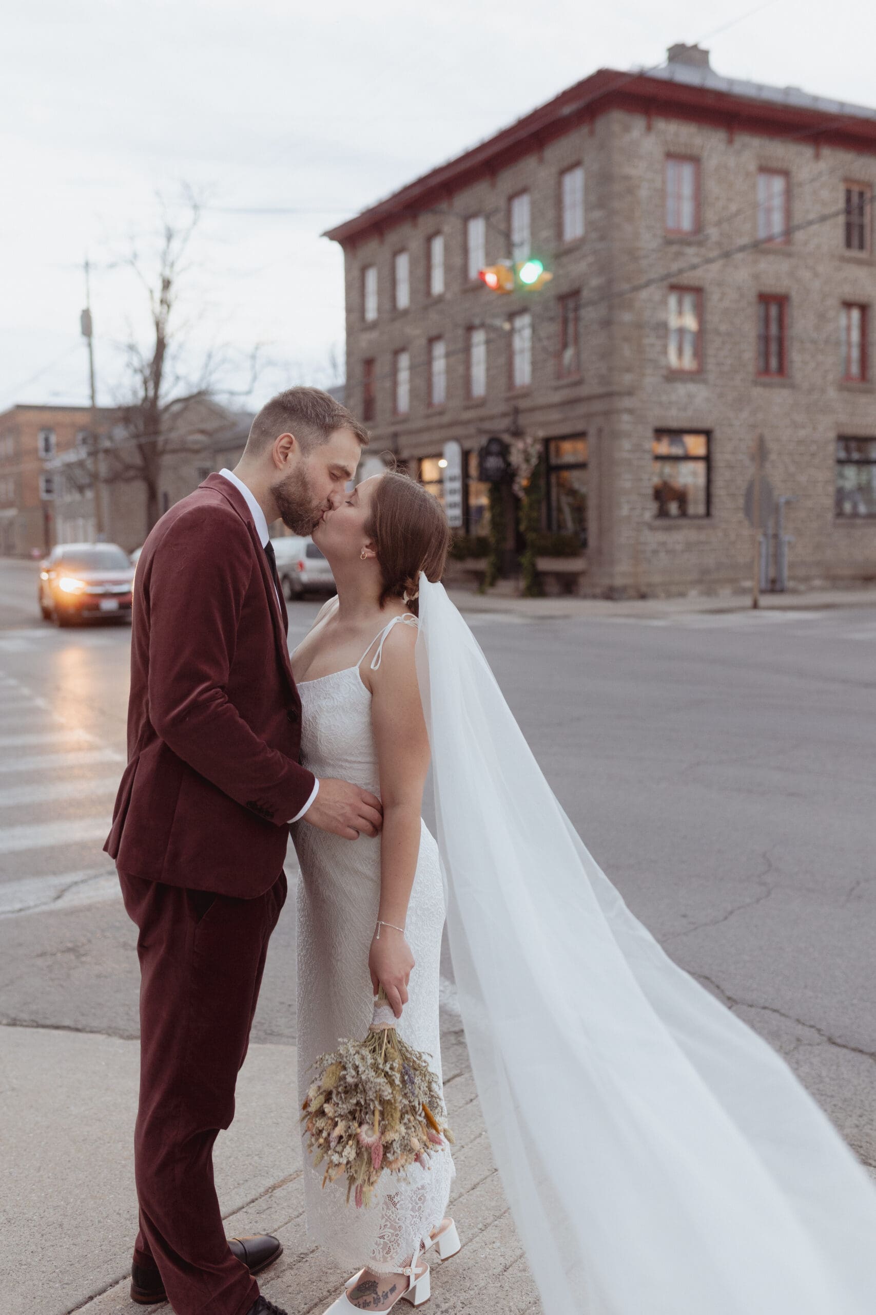 The bride and groom kissing at the intersection in Merrickville, Ontario.